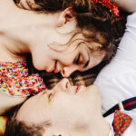 пара лежит на покрывале и улыбается